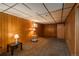 Cozy basement rec room featuring carpet, wood paneled walls, and ample lighting at 15930 E Ford Pl, Aurora, CO 80017