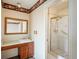Bathroom showcasing a sink vanity, toilet and a tiled shower stall with a glass door, with floral border at 15930 E Ford Pl, Aurora, CO 80017