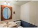 Bathroom featuring a single sink vanity, toilet, decorative mirror and two-tone paint for a simple, classic style at 15930 E Ford Pl, Aurora, CO 80017