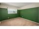 An interior shot of a bedroom with dark green walls, carpet and window at 15930 E Ford Pl, Aurora, CO 80017