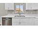 Modern kitchen with white cabinets, stainless steel appliances, and quartz countertops at 6087 W 61St Pl, Arvada, CO 80003