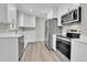 Modern kitchen with stainless steel appliances and white shaker cabinets at 6087 W 61St Pl, Arvada, CO 80003