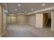 Finished basement space featuring neutral walls, carpet, lighting, and access to stairs at 20194 Robins Dr, Denver, CO 80249