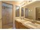Bright bathroom with a double sink vanity and large, glass-enclosed walk-in shower at 20194 Robins Dr, Denver, CO 80249