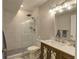 Bathroom with tiled shower, mosaic floor, vanity, mirror, and gray paint at 20194 Robins Dr, Denver, CO 80249