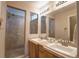 Bathroom with double sinks, tiled floor and shower with glass surround at 20194 Robins Dr, Denver, CO 80249
