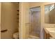 Modern bathroom featuring a glass enclosed shower, toilet, and wall shelves at 20194 Robins Dr, Denver, CO 80249