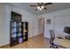 Bright bedroom features wood floors, ceiling fan, large bookcase, and sliding-door closet at 20194 Robins Dr, Denver, CO 80249