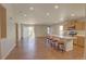 Bright, open-concept living area flows into a kitchen with a breakfast bar and wood floors at 20194 Robins Dr, Denver, CO 80249
