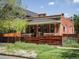 Inviting brick home featuring a decorative wooden fence and a cozy covered front porch at 3914 Osage St, Denver, CO 80211