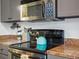 Kitchen featuring a stove and microwave, granite countertops, and updated appliances at 3914 Osage St, Denver, CO 80211