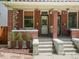 Inviting front porch with potted plants, a seating area, and brick columns at 3914 Osage St, Denver, CO 80211