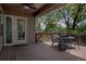Spacious covered back deck with ceiling fan, wooden railing, and outdoor seating with tree-lined views at 12631 W Dakota Dr, Lakewood, CO 80228