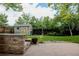 Landscaped backyard featuring a well-maintained lawn, a patio, and a storage shed with mature trees and fencing at 12631 W Dakota Dr, Lakewood, CO 80228