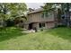 Exterior shot of the home's backyard, with a deck, grassy yard, and mature trees creating a private oasis at 12631 W Dakota Dr, Lakewood, CO 80228