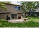 View of the back of the house including a patio, grassy yard, and mature trees for outdoor living at 12631 W Dakota Dr, Lakewood, CO 80228