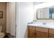 Well-lit bathroom featuring a vanity with light wood cabinets, a white countertop, and a shower with a white curtain at 12631 W Dakota Dr, Lakewood, CO 80228