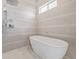 Bathroom featuring luxurious tub and shower with tiled walls and a small window at 2350 Tremont Pl # 13, Denver, CO 80205