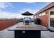 Relaxing rooftop terrace with a fire pit, outdoor seating, grill, and spa, perfect for entertaining and enjoying city views at 2350 Tremont Pl # 13, Denver, CO 80205