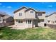 A sunny backyard showing the home's exterior, including a well-kept lawn, patio area, and charming bay window feature at 13846 Harrison Dr, Thornton, CO 80602