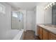 Bright bathroom features a tub, shower, and double vanity, providing ample space and natural light at 13846 Harrison Dr, Thornton, CO 80602