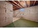 Unfinished basement with exposed ceiling, concrete walls, and green carpet at 4155 W Harvard Ave, Denver, CO 80219