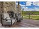 Covered deck with stone fireplace, mountain views, and patio seating at 60 Barton Ridge Dr, Breckenridge, CO 80424