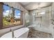 This bathroom has a free standing tub, glass enclosed shower, tile flooring, and a beautiful view at 60 Barton Ridge Dr, Breckenridge, CO 80424