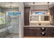 This bathroom features granite counters, dark wood cabinets, tile flooring, and a glass enclosed shower at 60 Barton Ridge Dr, Breckenridge, CO 80424