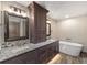 Bright bathroom featuring double vanity with granite countertop, dark wood cabinets and a modern soaking tub at 60 Barton Ridge Dr, Breckenridge, CO 80424