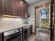 Convenient laundry room with large window, modern washer and dryer, and beautiful stone tile floor at 60 Barton Ridge Dr, Breckenridge, CO 80424