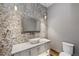 Charming powder room with stone accent wall, vessel sink, and unique lighting at 60 Barton Ridge Dr, Breckenridge, CO 80424