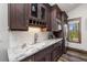 Charming wet bar with dark wood cabinetry, white backsplash, and stainless-steel refrigerator at 60 Barton Ridge Dr, Breckenridge, CO 80424