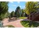 Expansive backyard with lush greenery, stone pathways, and a tranquil garden setting at 7346 S Platte Canyon Dr, Littleton, CO 80128