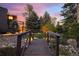 A lovely backyard includes a small wooden bridge and beautiful mature trees, with landscape lighting at 7346 S Platte Canyon Dr, Littleton, CO 80128