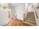 Hallway featuring hardwood floors, stairs to upper level, and access to the kitchen at 7346 S Platte Canyon Dr, Littleton, CO 80128