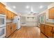 Eat-in kitchen with oak cabinetry, hardwood flooring, and stainless steel appliances at 7346 S Platte Canyon Dr, Littleton, CO 80128