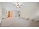 Spacious living room featuring neutral carpet, ceiling fan, and access to outdoor deck at 7346 S Platte Canyon Dr, Littleton, CO 80128