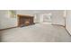 Expansive living room featuring plush carpeting, a brick fireplace, and ample natural light at 7346 S Platte Canyon Dr, Littleton, CO 80128