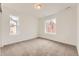 Cozy bedroom with neutral carpet, white walls, and two large windows offering plenty of natural light at 8846 Waterleaf Ln, Littleton, CO 80125