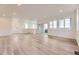 Spacious open floor plan featuring wood-look floors, recessed lighting, and sliding glass doors to a balcony at 8846 Waterleaf Ln, Littleton, CO 80125
