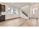 Bright open living space with wood-look floors, large windows and easy access to the staircase at 8846 Waterleaf Ln, Littleton, CO 80125