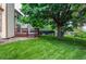 Green backyard boasts a wooden deck and mature trees offering plenty of shade and privacy at 9614 W Powers Cir, Littleton, CO 80123