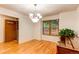 Bright dining room with hardwood floors, chandelier, window, and piano at 9614 W Powers Cir, Littleton, CO 80123