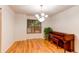 Bright dining room featuring hardwood floors, chandelier, window, and piano at 9614 W Powers Cir, Littleton, CO 80123