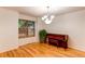 A chandelier lights a dining room with hardwood floors and a window at 9614 W Powers Cir, Littleton, CO 80123