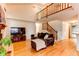 Living room featuring hardwood floors, a large sofa, and a staircase leading to the upper level at 9614 W Powers Cir, Littleton, CO 80123
