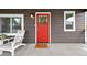 Inviting front porch featuring a red door with wreath, 'Welcome' doormat, and a comfortable lounge chair at 800 S Krameria St, Denver, CO 80224