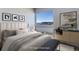 A staged bedroom with a neutral color palette, large window, and modern furnishings at 2460 W 29Th Ave # 303, Denver, CO 80211
