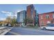 Street-level view of building's blue apartments and brick tower on a sunny day at 2460 W 29Th Ave # 303, Denver, CO 80211